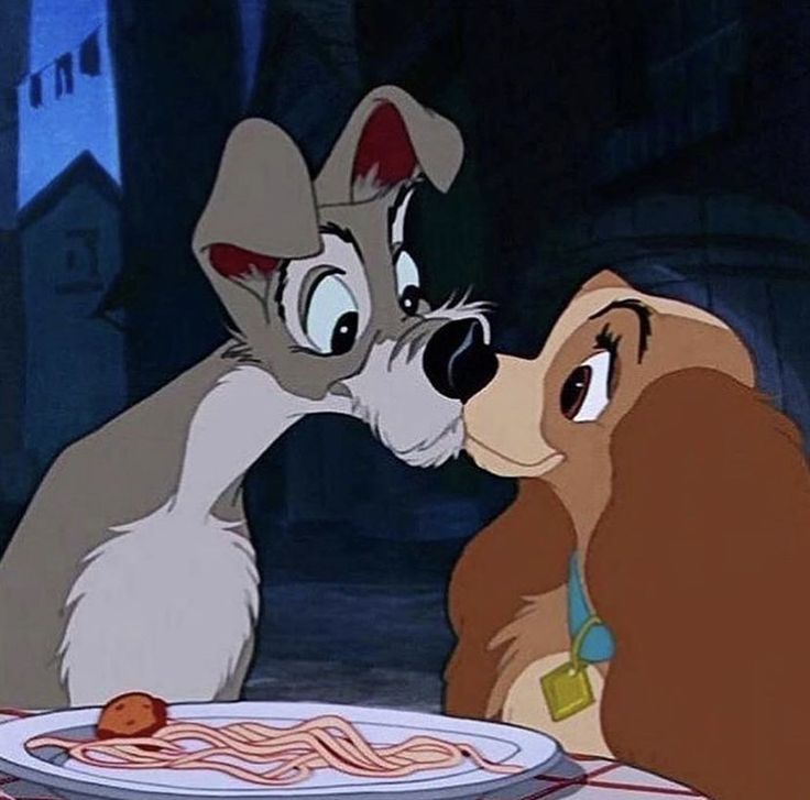 lady and the tramp kissing in front of a plate of spaghetti