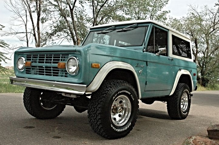 a green truck parked on the side of a road