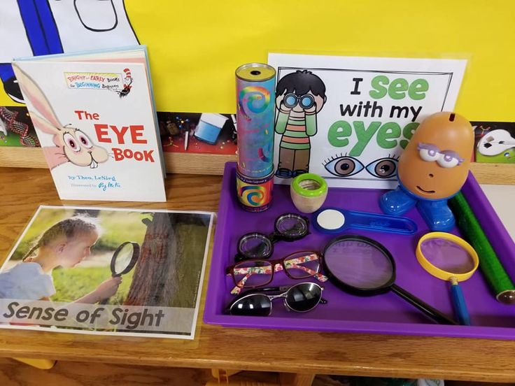 an assortment of children's toys and books on a purple tray with the words i see with my eye book