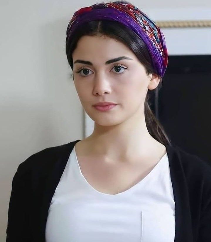 a woman wearing a white t - shirt and a purple headband is looking at the camera