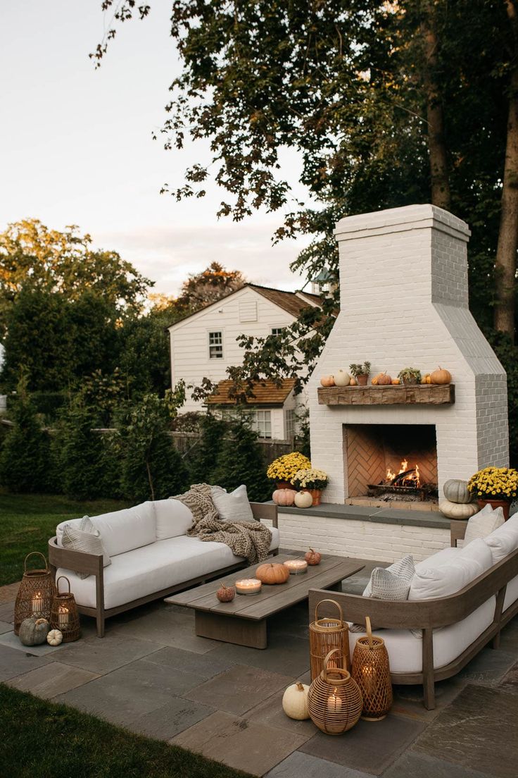 an outdoor fireplace with couches and tables in front of it