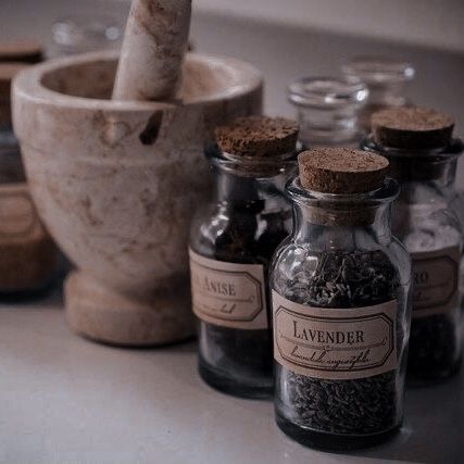 several bottles with spices in them sitting on a counter next to a mortar and mortar bowl