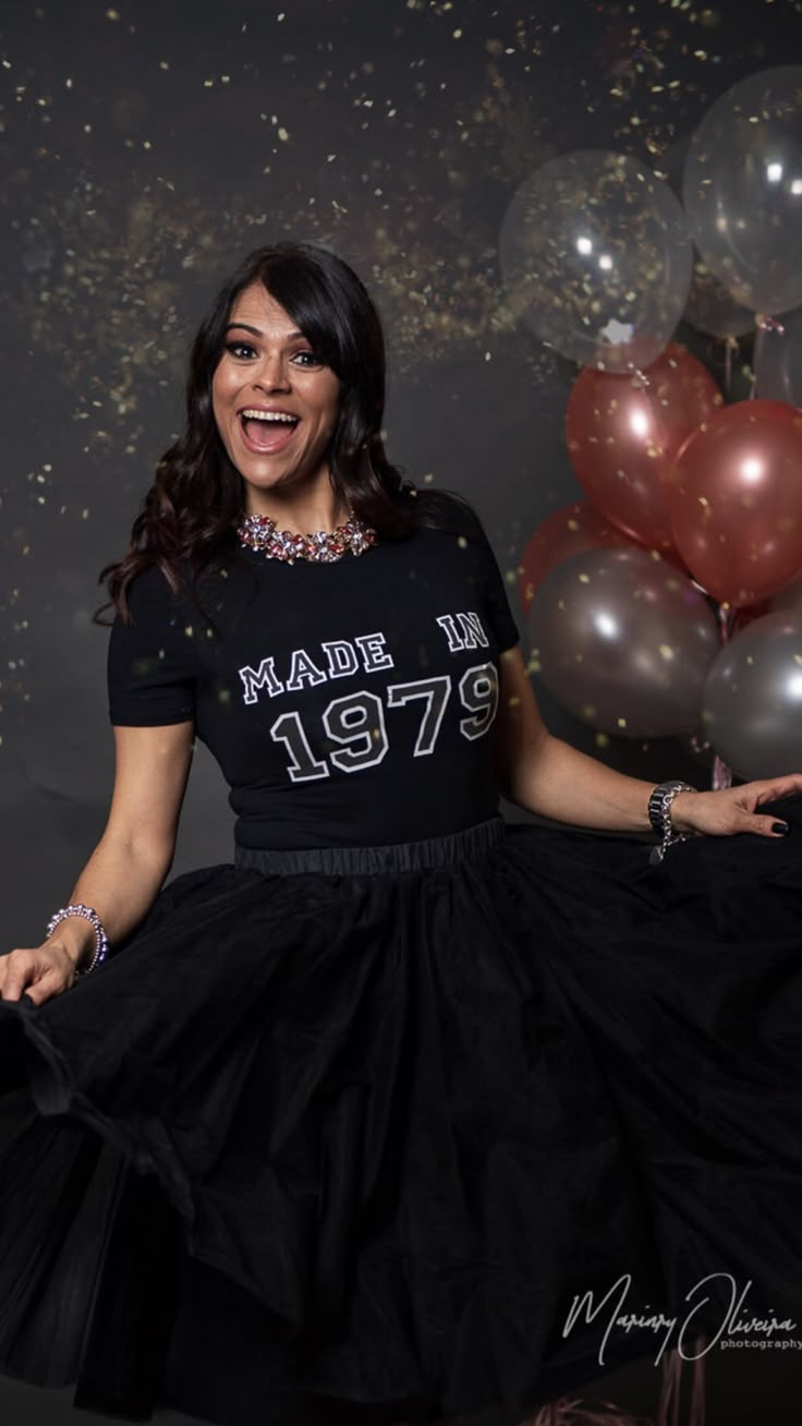 a woman in a black dress and some balloons