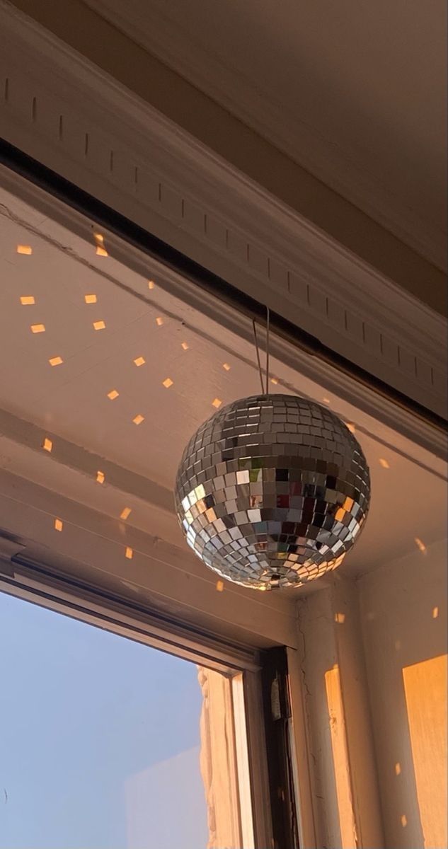 a disco ball hanging from the ceiling in front of a window