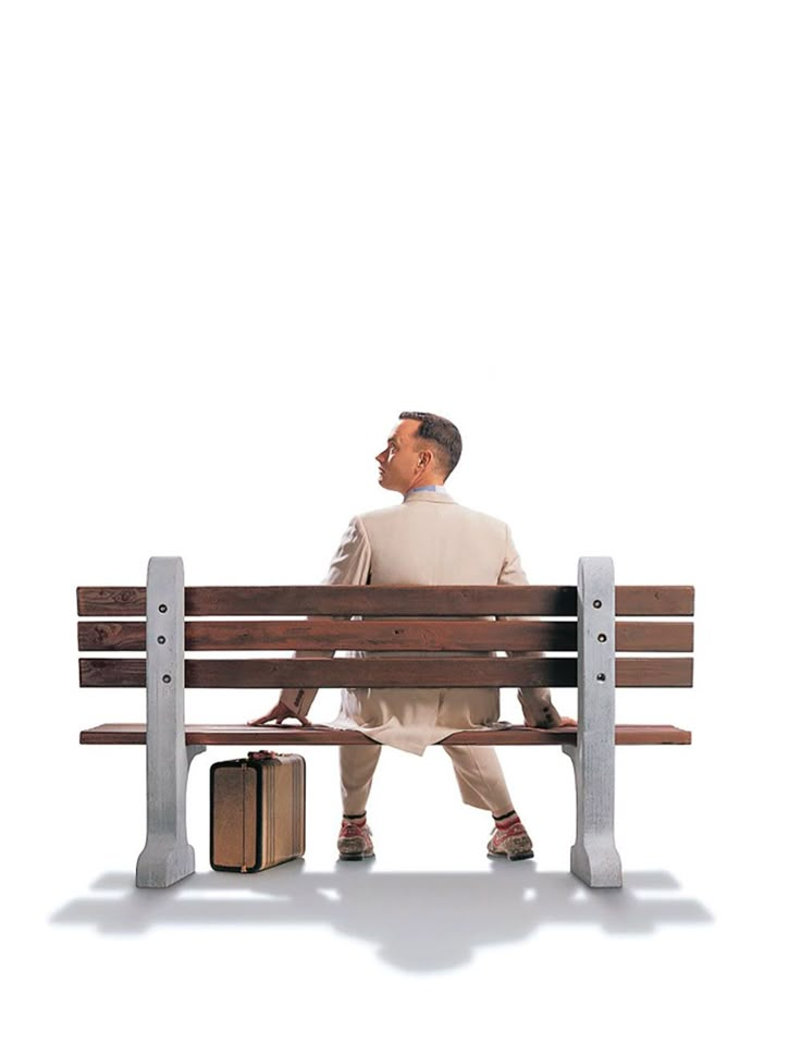 a man sitting on top of a wooden bench