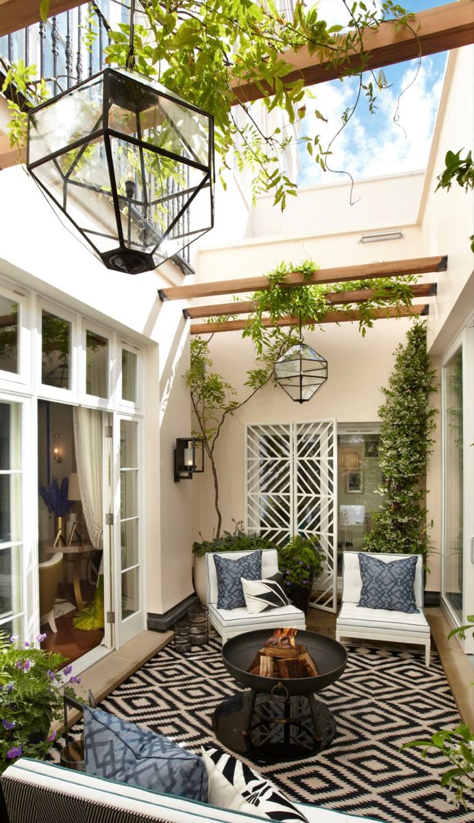 an outdoor living area with white furniture and plants