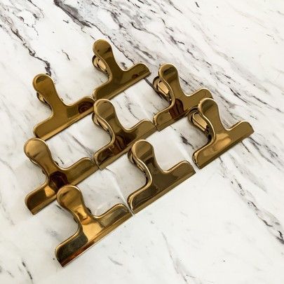 four brass handles on a marble counter top