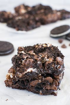 a close up of a piece of cake with oreo cookies in the background