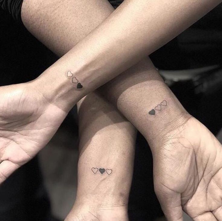 two people with matching tattoos on their hands