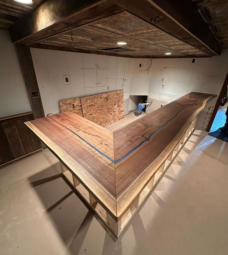 an unfinished wooden counter in the middle of a room