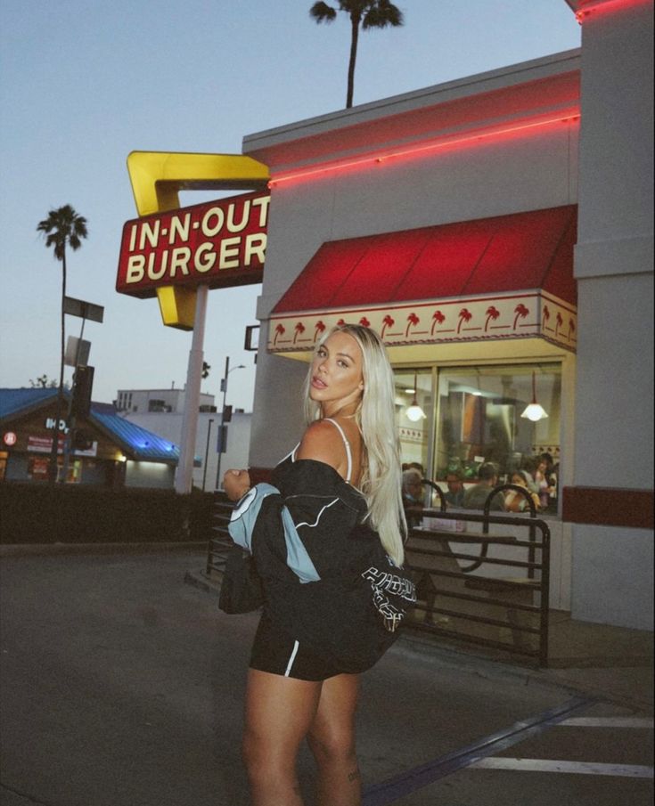 a woman standing in front of a fast food restaurant