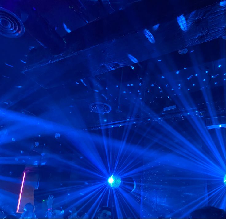 blue lights shine brightly in the dark on a dance floor at a concert or club