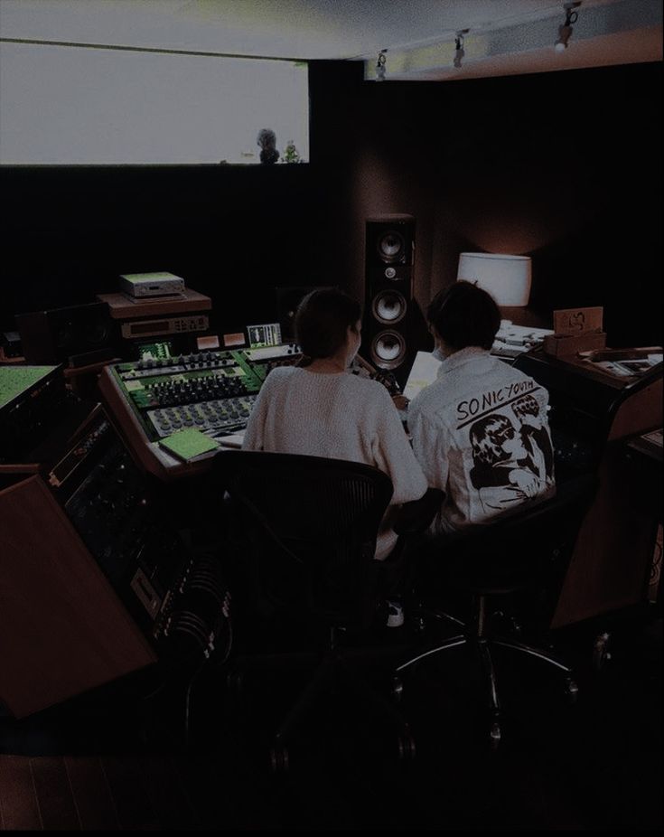 two people sitting in front of sound mixing equipment