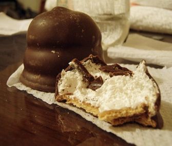 a piece of cake sitting on top of a table next to a chocolate covered object