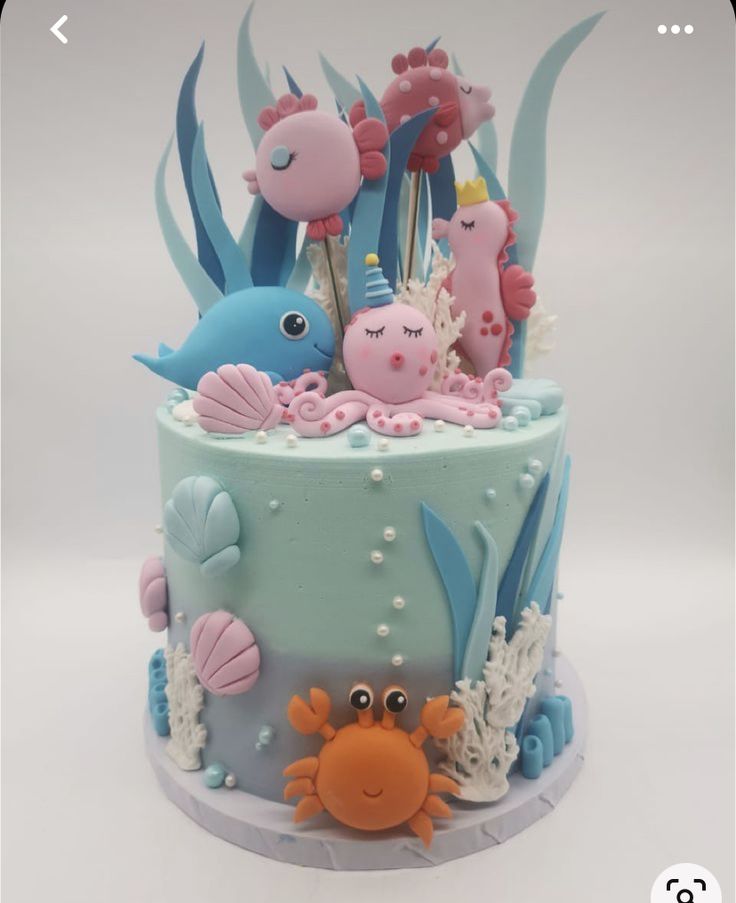 there is a cake decorated with sea animals and fish on the bottom, along with other decorations