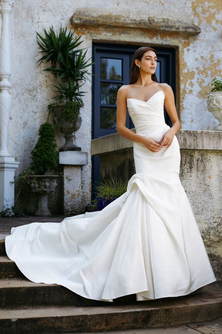 a woman in a wedding dress standing on some steps