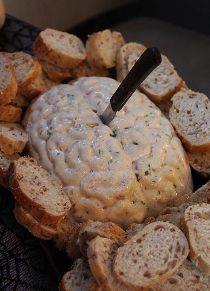 an appetizer with bread and dip in the middle, on top of it