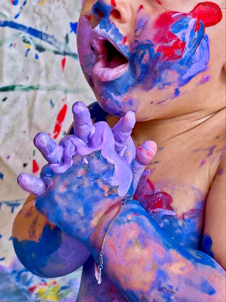 a baby covered in blue and purple paint