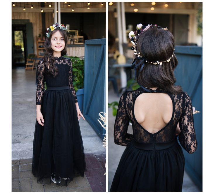 a girl wearing a black dress with flowers in her hair, standing on the sidewalk