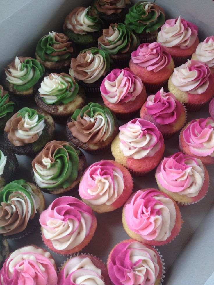 a box filled with lots of different colored cupcakes