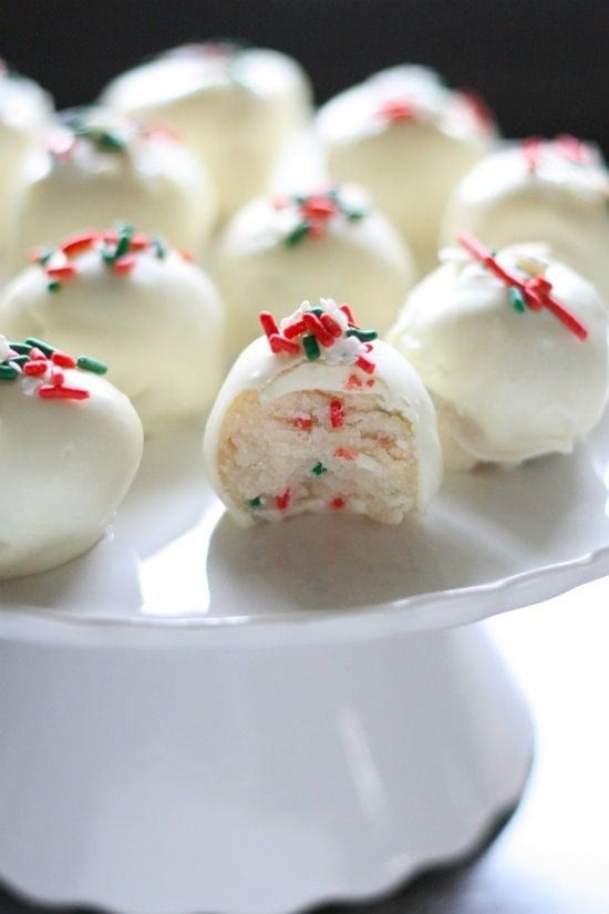 white chocolate covered desserts with sprinkles on a plate