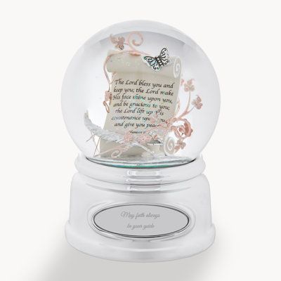 a glass snow globe with a poem in it on a white base and pink flowers