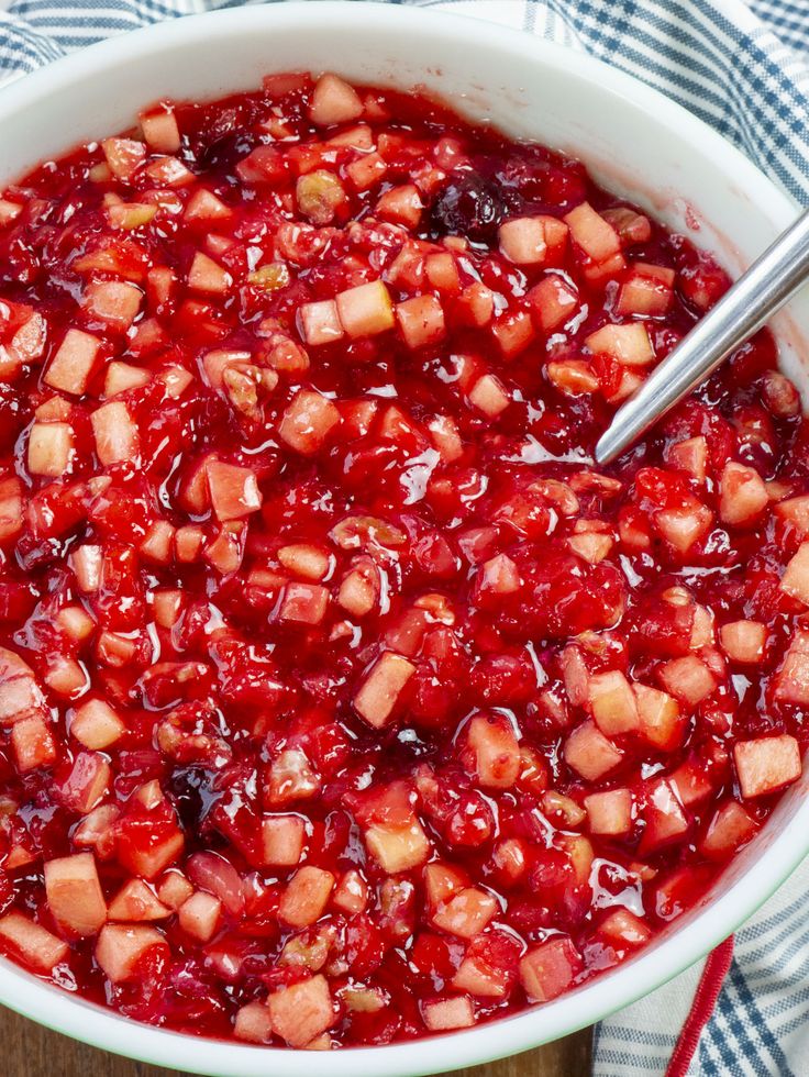 a white bowl filled with cranberry sauce on top of a wooden table