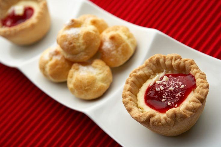 small pastries are sitting on a white plate with red table cloth and striped tablecloth