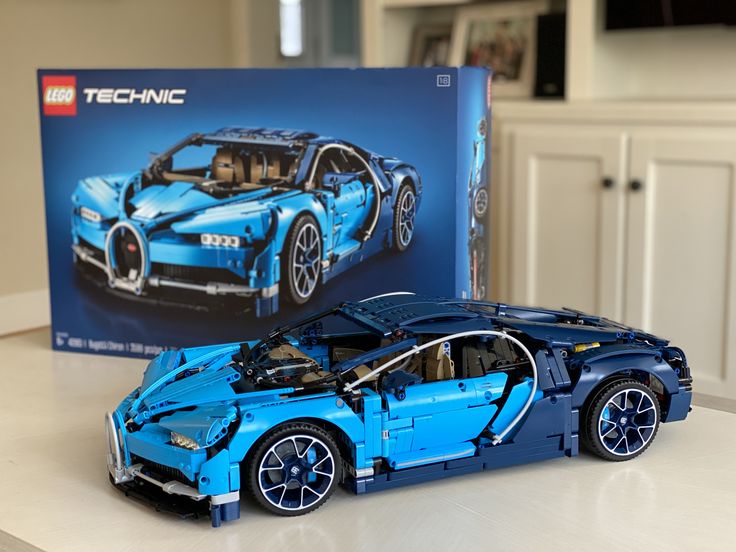 a blue lego bugatti is sitting on a table next to a box that says technic