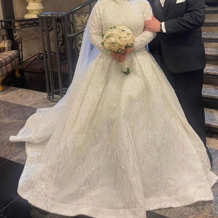 a man and woman in formal wear standing next to each other on the stairs at their wedding