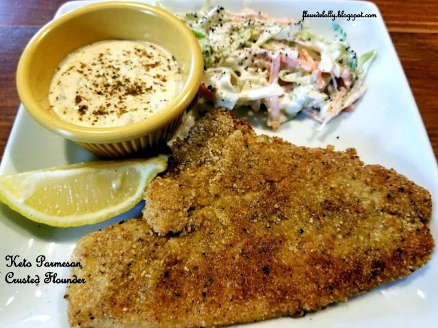 a white plate topped with fish and coleslaw next to a bowl of sauce