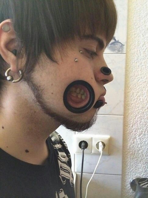 a man with piercings on his ears and nose