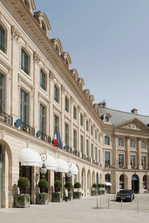 a large building with many windows and balconies on the front, next to a parking lot