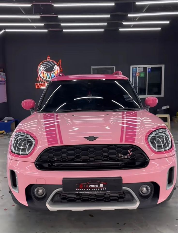 the front end of a pink car in a garage