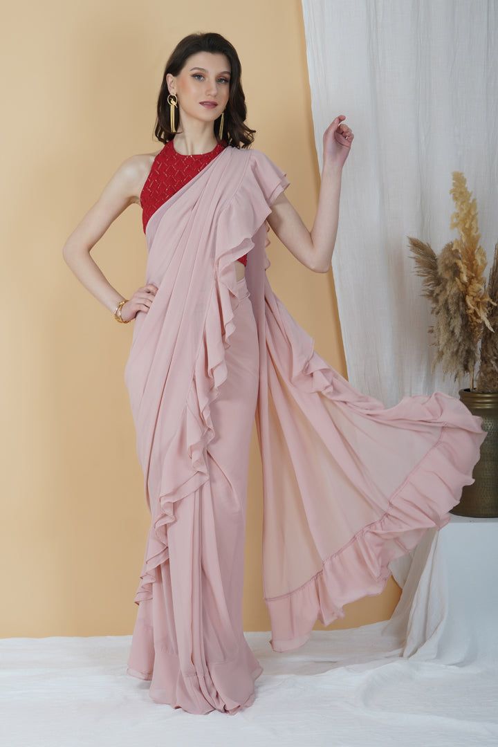 Be it a cocktail party or a day event, put your best foot forward in this stunning frilly saree! With an embellishments red halter neck blouse and a monotone hued blush pink saree, this combination is an eclectic choice for days when you want your look to be chic and sophisticated.Style Blush pink hue Halter neck blouse Frilly Saree Contrasting Combination Georgette fabric Specifications Model height - 5'7" Model wearing - S Pink Sleeveless Pre-draped Saree For Diwali, Bollywood Evening Blouse With Ruffles, Floor-length Ruffled Blouse Piece For Party, Semi-stitched Draped Blouse Piece For Party, Summer Party Pre-draped Saree, Evening Blouse Piece With Ruffles For Diwali, Diwali Evening Blouse Piece With Ruffles, Evening Diwali Blouse Piece With Ruffles, Diwali Evening Ruffled Blouse Piece