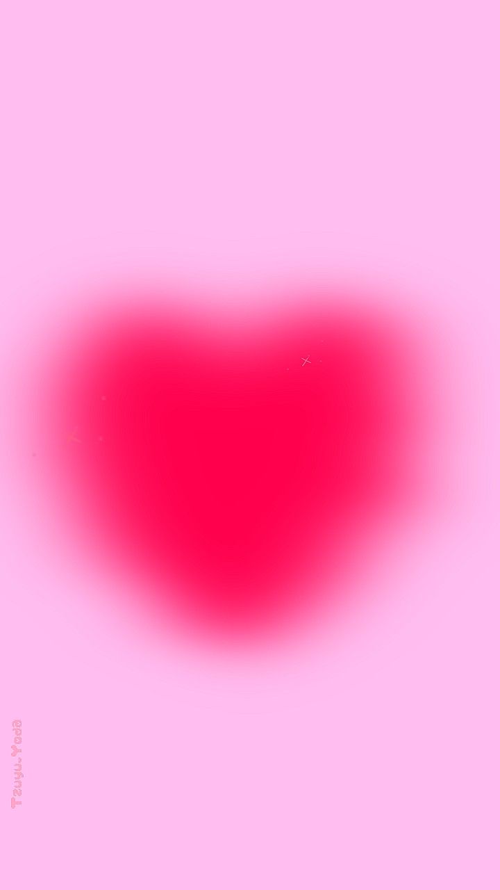 a blurry image of a red heart on a pink background with the word love written below it