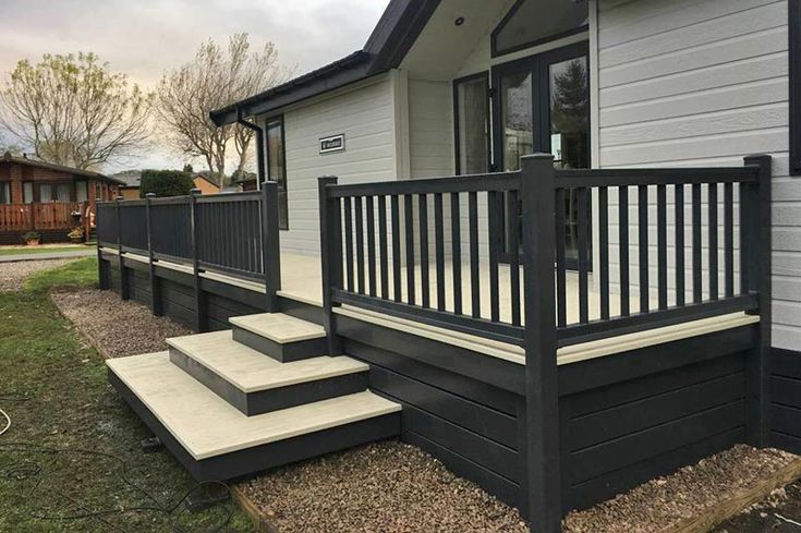 a mobile home with steps leading up to the front door and side porches on either side of the house