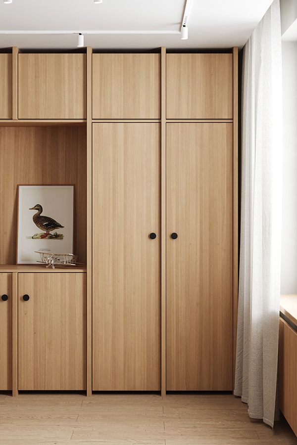 an empty room with wooden cupboards and pictures on the wall in front of it