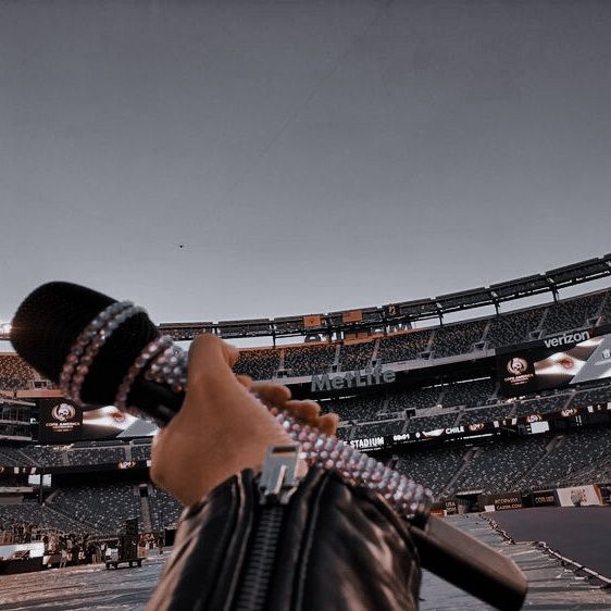 a person holding a baseball bat in front of an empty stadium