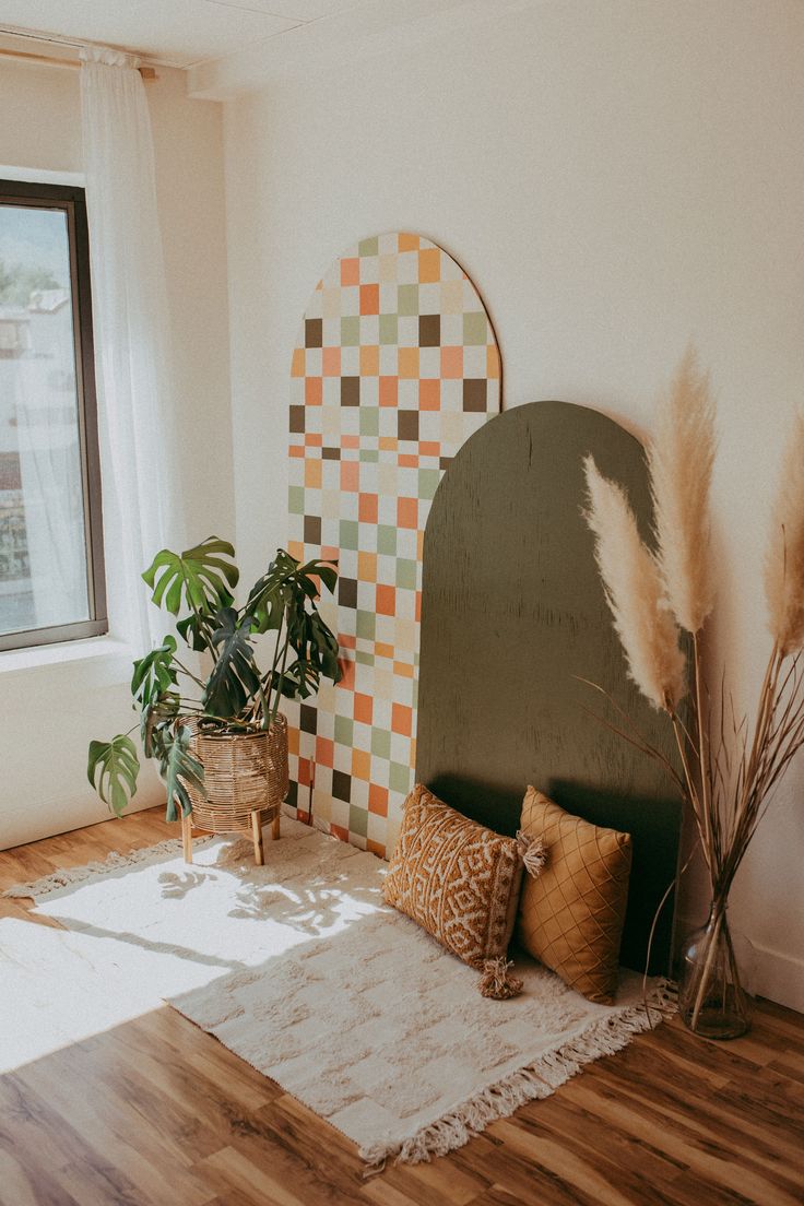 a room with some plants and pillows on the floor