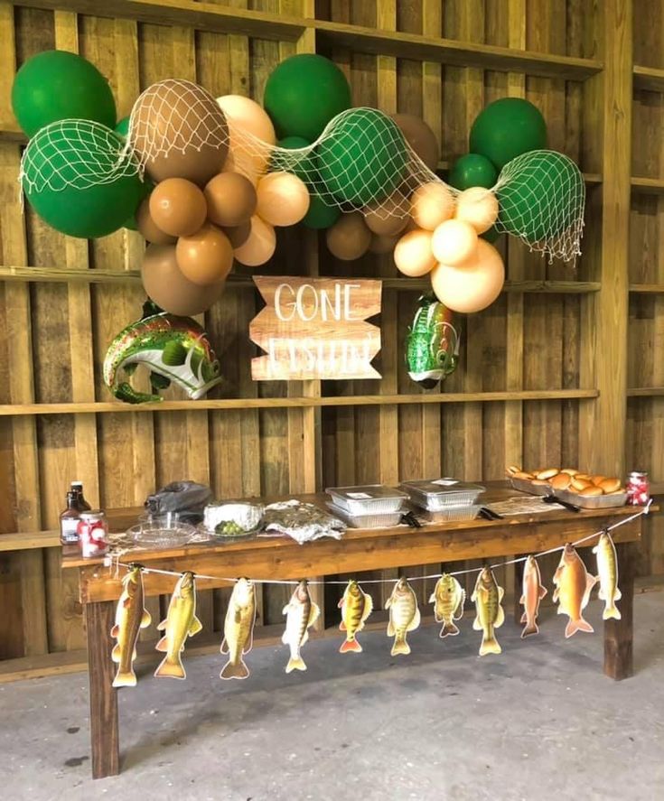 a table with some fish hanging from it's sides in front of a wooden wall