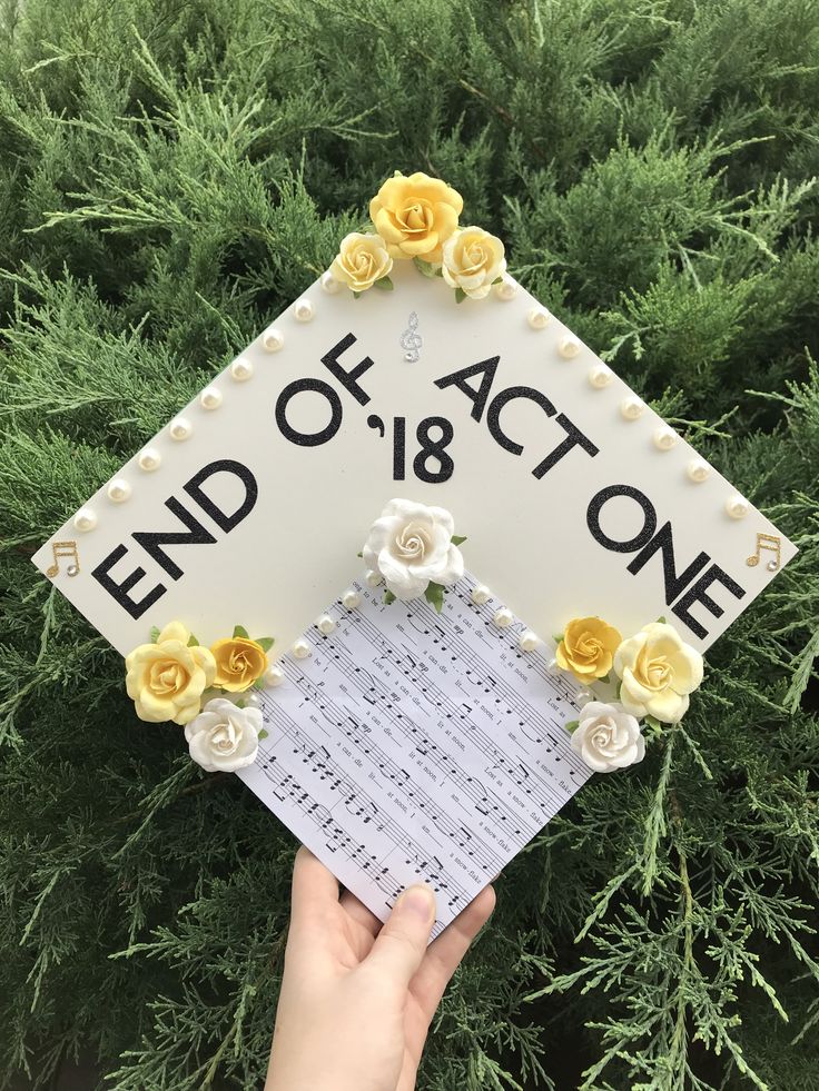 someone is holding up a sign that says end of act one with flowers on it