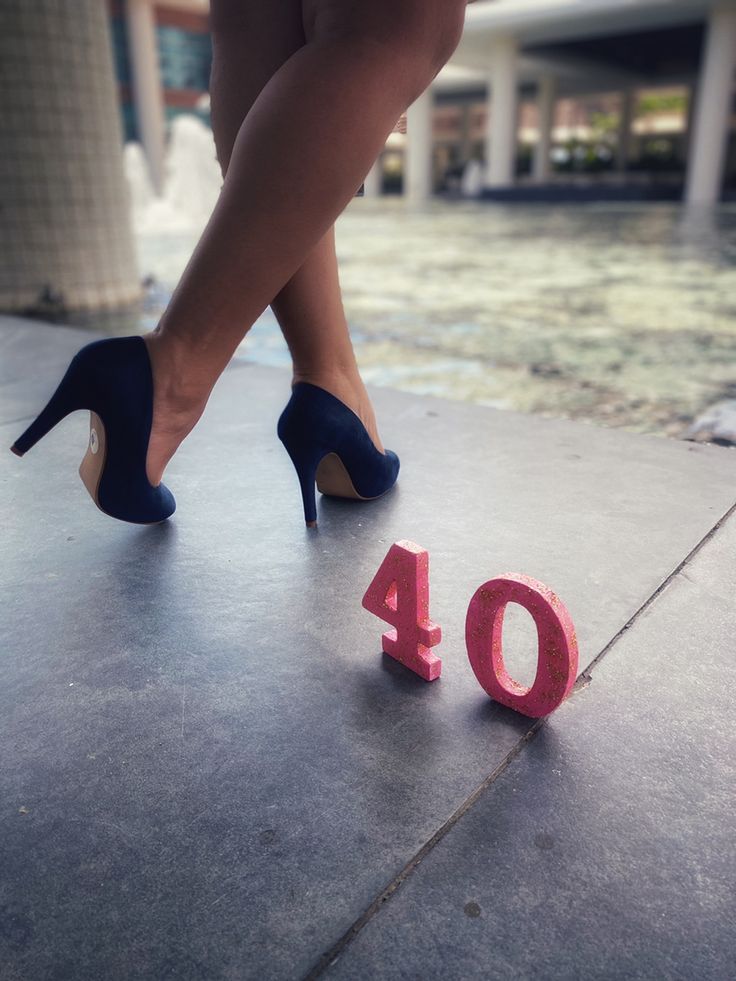 a woman in high heels standing next to the number forty