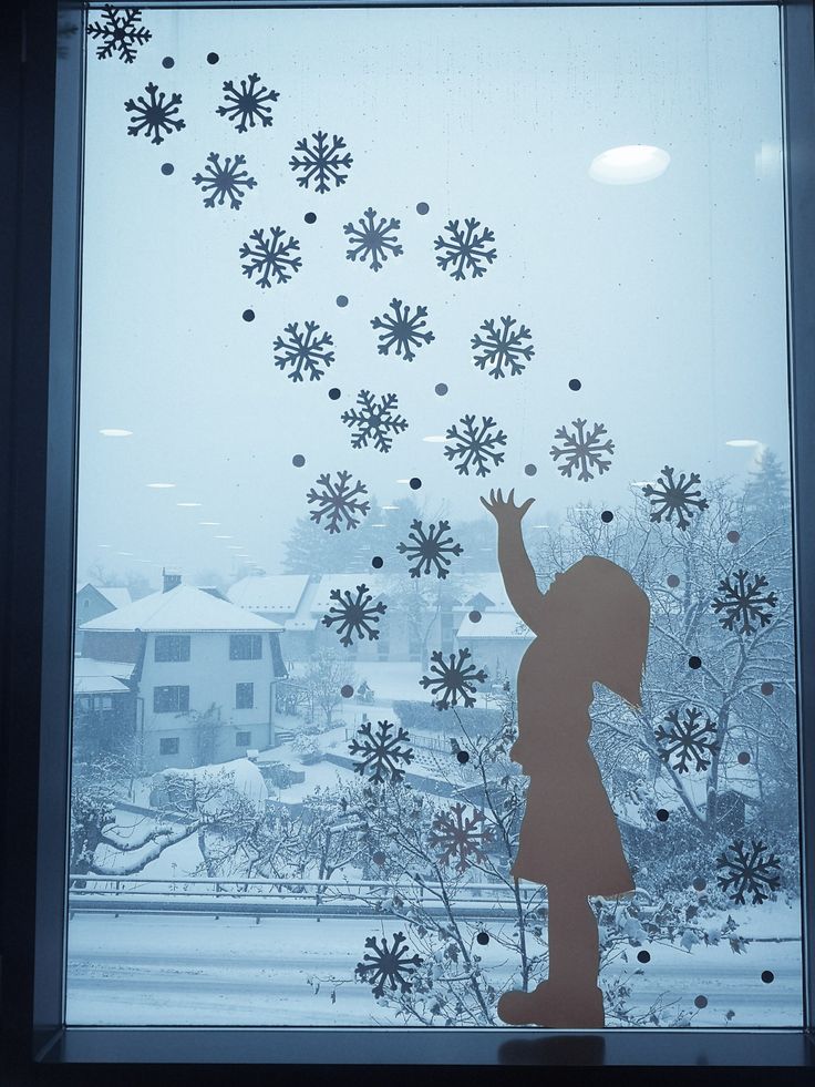 a window with snowflakes on it and a girl reaching up to the sky