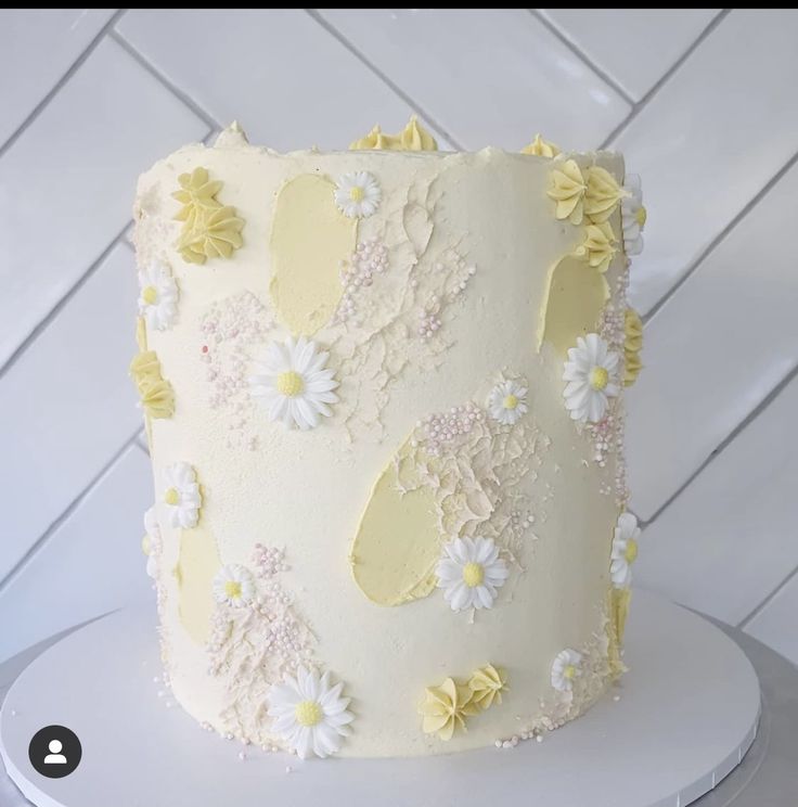 a white cake with yellow and white flowers on it