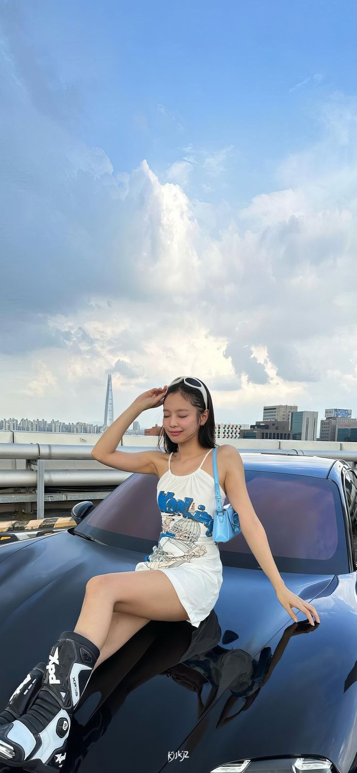 a woman sitting on the hood of a car