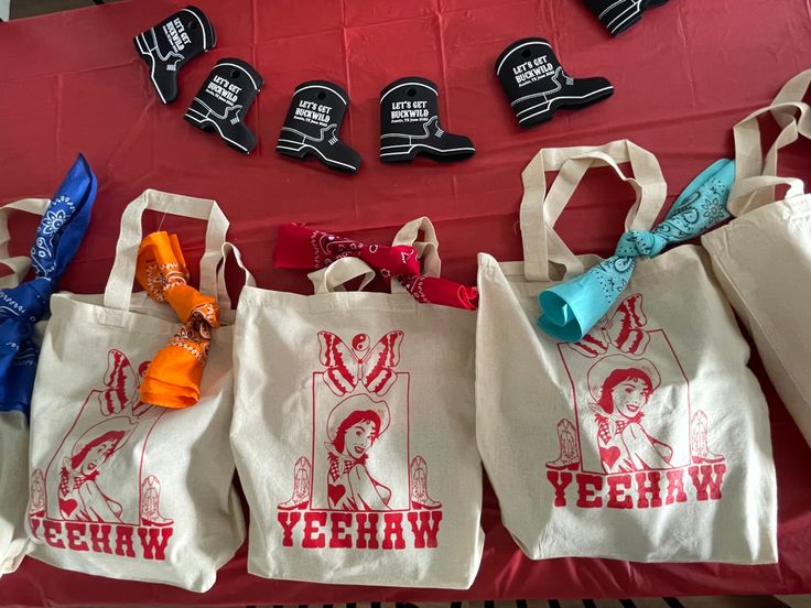 several bags are lined up on a table with candy and other items in front of them