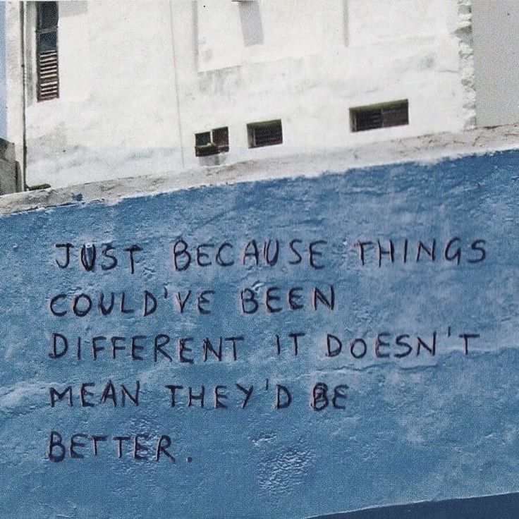 graffiti written on the side of a blue wall in front of a building that says, just because things could't be seen different if it doesn't mean they'd