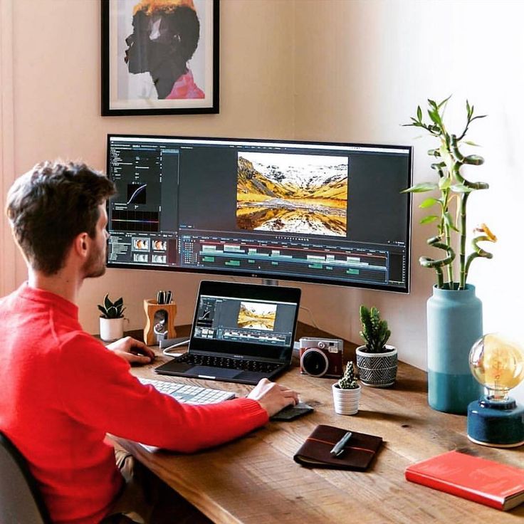 a man sitting at a desk in front of a computer monitor with multiple images on it