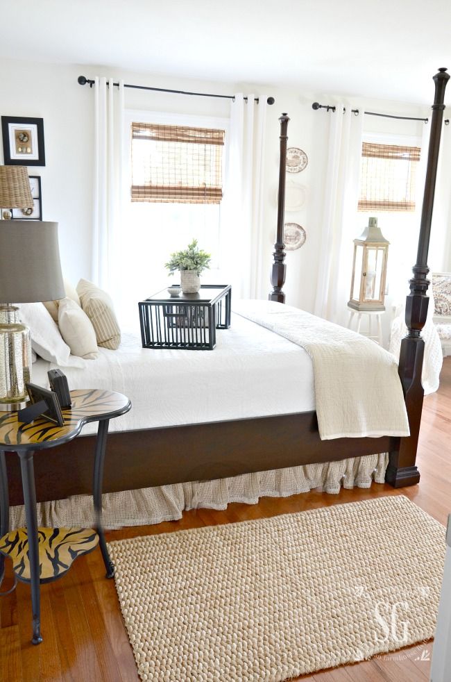 a bedroom with white bedding and wooden floors